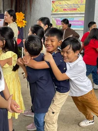Two children play and embrace warmly at a school event.